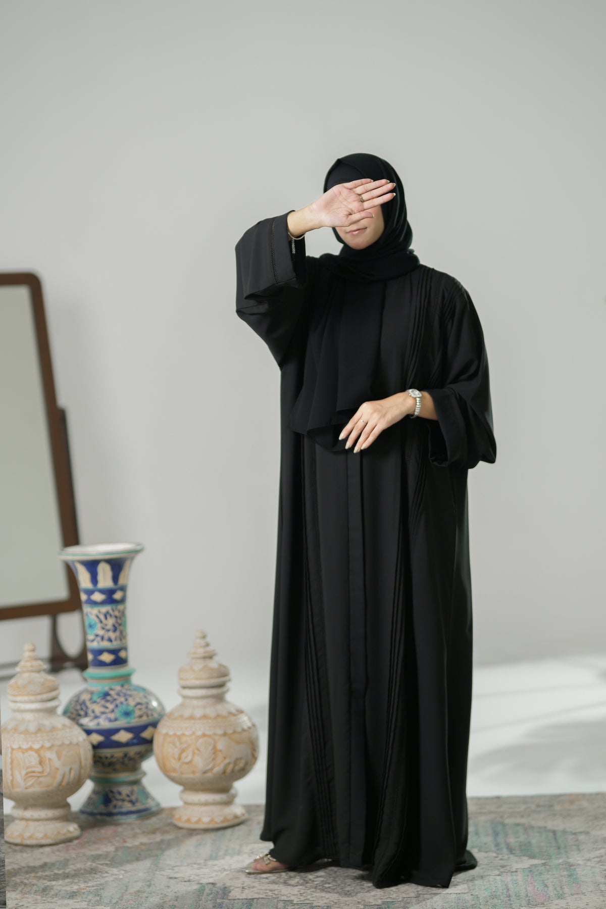 A lady wearing Black pleated and lace Abaya
